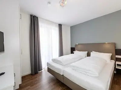 Schlafzimmer mit Doppelbett und TV
