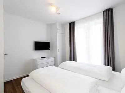 Schlafzimmer mit Doppelbett und TV