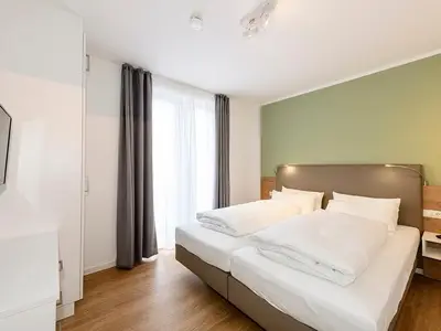 Schlafzimmer mit Doppelbett und TV