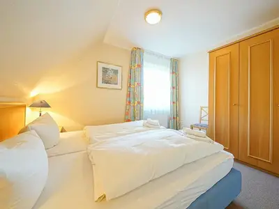 Schlafzimmer mit Doppelbett und Kleiderschrank