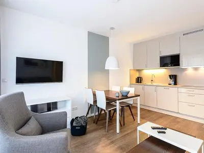 Wohn/Essbereich mit Esstisch, Sessel, TV und Küchenzeile