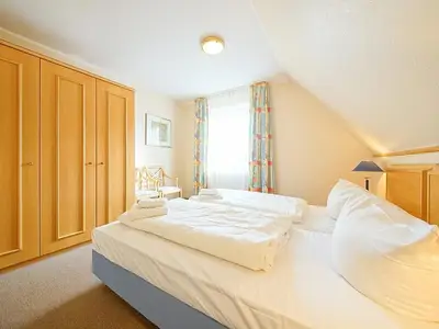 Schlafzimmer mit Doppelbett und Kleiderschrank