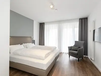 Schlafzimmer mit Doppelbett, Couch und TV