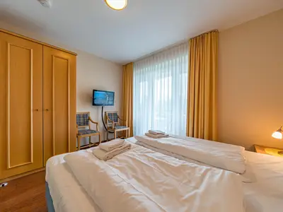 Schlafzimmer mit Kleiderschrank und TV