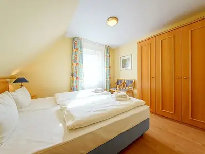 Schlafzimmer mit Doppelbett und Kleiderschrank