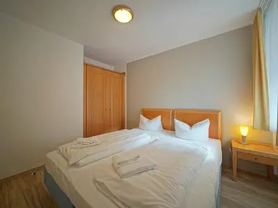 Schlafzimmer mit Doppelbett und Kleiderschrank