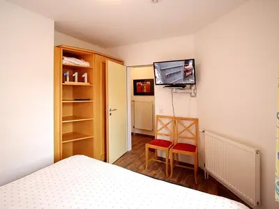 Schlafzimmer mit Kleiderschrank und TV