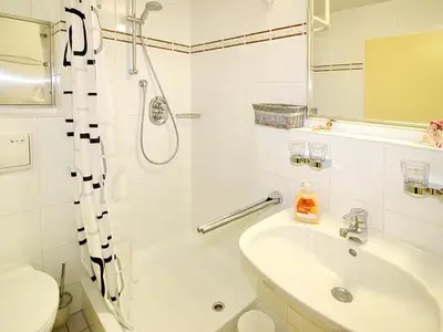 Badezimmer mit Dusche, Waschtisch, WC und Spiegel