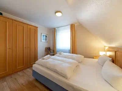 Schlafzimmer mit Doppelbett und Kleiderschrank