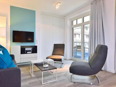 Wohn/ Essbereich mit Couch, zwei Sessel und Fernseher