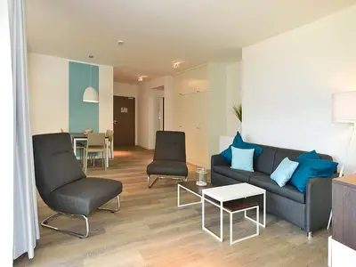 Wohn/ Essbereich mit Couch, zwei Sessel und Tisch