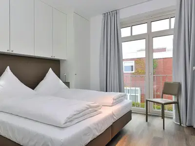 Schlafzimmer mit Doppelbett und Sitzgelegenheit