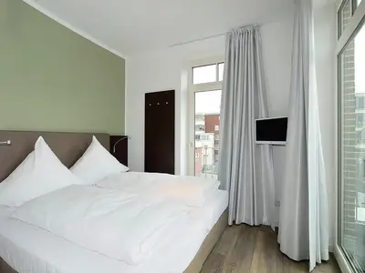 Schlafzimmer mit Doppelbett und Fernseher
