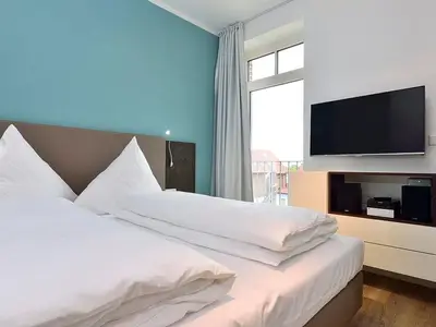 Schlafzimmer mit Doppelbett und Fernseher