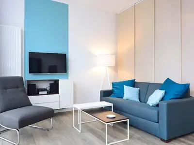 Wohn/ Essbereich mit Couch, Sessel und Tisch