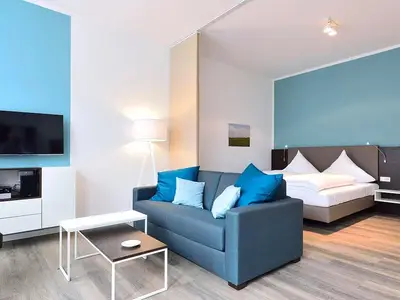 Wohn/ Essbereich mit Couch, Tisch und Fernseher