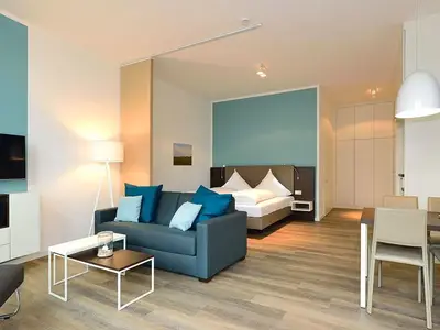 Wohn/ Essbereich mit Couch, Fernseher und Esstisch