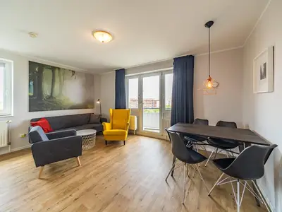 Wohnbereich mit Sofa, Sessel, Couchtisch und Esstisch