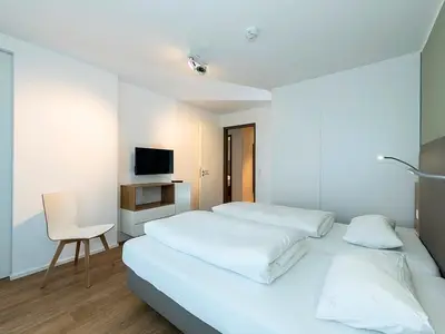 Schlafzimmer mit Doppelbett, Kleiderschrank und TV