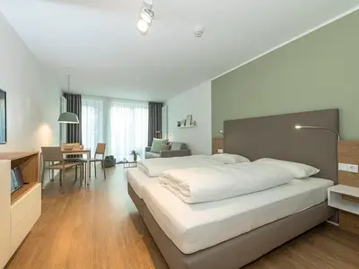 Schlafzimmer mit Doppelbett und TV