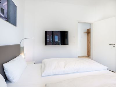 Schlafzimmer mit Doppelbett und TV