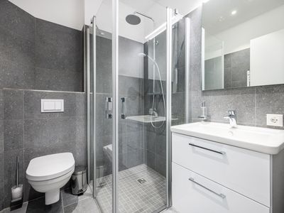 Badezimmer mit Dusche, Waschtisch, WC und Spiegel
