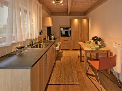 Moderne und vollständig eingerichtete Holzküche, ganz wie zu Hause