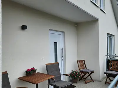 gemütliche rund teilweise überdachter Balkon mit der Eingangstür