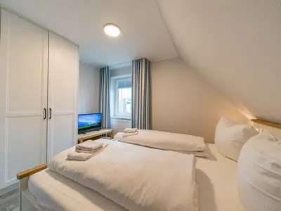 Schlafzimmer mit Kleiderschrank und TV