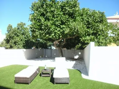 Garten mit Liegestühlen und Olivenbaum