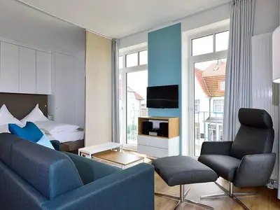 Wohn/ Essbereich mit Couch, Tisch und Fernseher