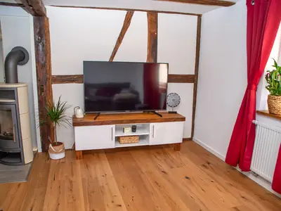 Wohnzimmer mit Kaminofen und Smart TV