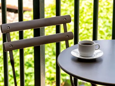 Ausblick aus dem Fenster. Kleiner Balkon mit Sitzgelegenheit