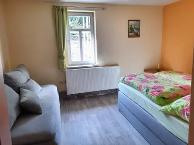 Schlafzimmer mit Doppelbett und Schlafcouch