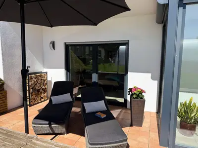 Terrasse mit gepolsterten Liegestühlen