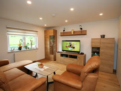 Wohnzimmer mit gemütlicher Couchecke und 50 Zoll Fernseher