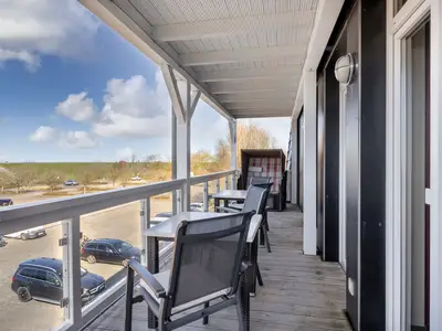 Überdachter Balkon mit Sitzgelegenheit und Strandkorb