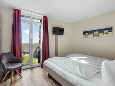 Schlafzimmer mit Doppelbett und TV