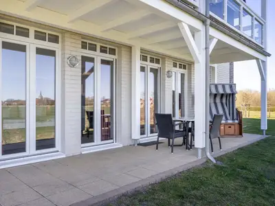 Überdachte Terrasse mit Sitzgelegenheit und Strandkorb