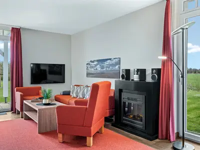 Wohnbereich mit Sofa, Sessel, Couchtisch und Kamin
