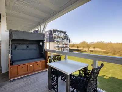 Überdachter Balkon mit Sitzgelegenheit und Strandkorb