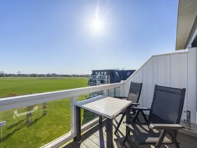 Balkon mit Tisch, Sitzgelegenheiten und Blick ins Grüne