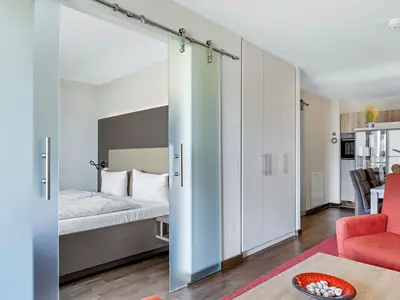 Wohnzimmer mit Kleiderschrank und Zugang Schlafzimmer