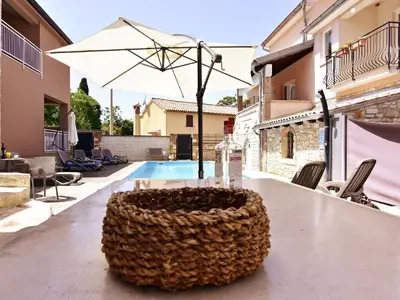 Der Poolbereich mit Liegestühlen und Sonnenschirmen