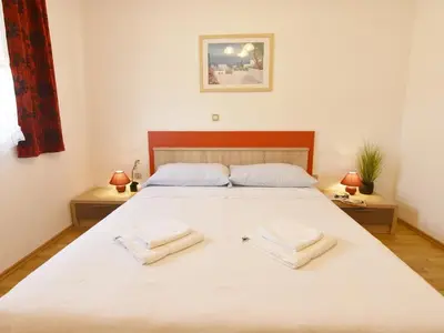 Schlafzimmer 1 mit Doppelbett, zwei Nachttische mit Nachttischlampen.