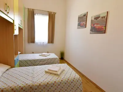 Schlafzimmer 2 mit zwei Einzelbetten und Kleiderschrank.