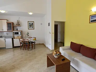 Der Wohnbereich mit Schlafcouch, Couchtisch, Essecke und Küche.
