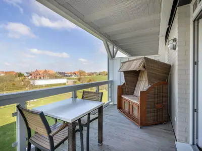Überdachter Balkon mit Sitzgelegenheit und Strandkorb