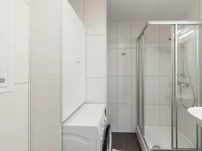 Badezimmer mit Dusche und Waschmaschine