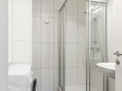 Badezimmer mit Dusche und Waschmaschine